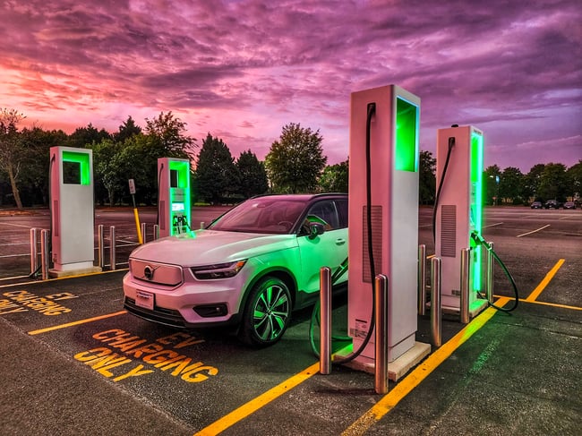 EV Ambassador Nicole Cooper Volvo XC40 charging at Electrify America stations epic sky glowing green for blog