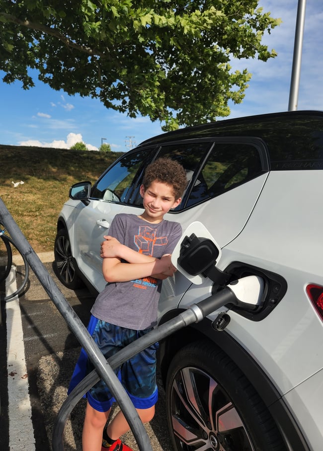 EV Ambassador Nicole Cooper kid leaning against Volvo XC40 charging GREAT PHOTO for blog