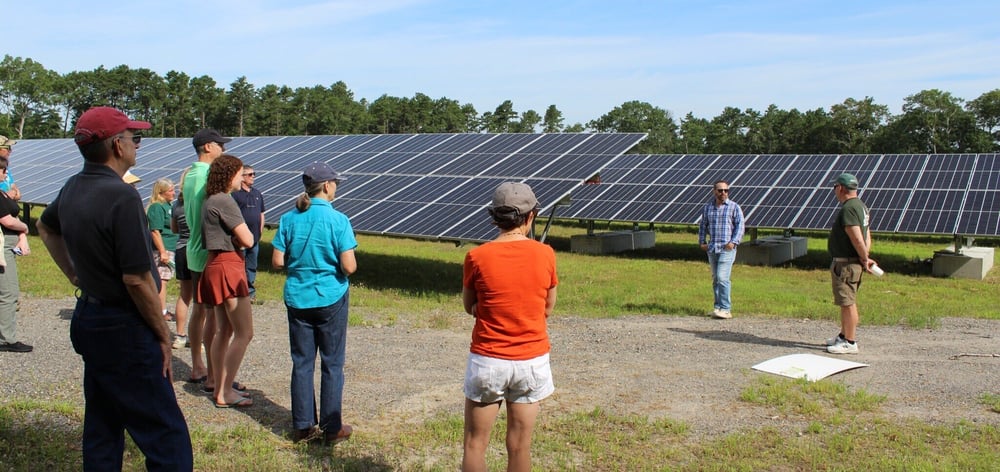 South Kingstown Solar Tour Larry SPeaking to group in front of solar panels